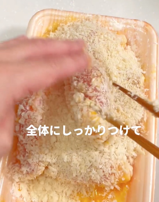 ハムを巻いた豚薄切り肉にパン粉をまぶす様子