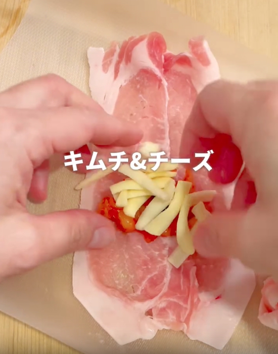 豚肉の上にチーズとキムチをのせている様子