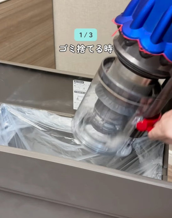 掃除機のダストカップからゴミを捨てようとする様子