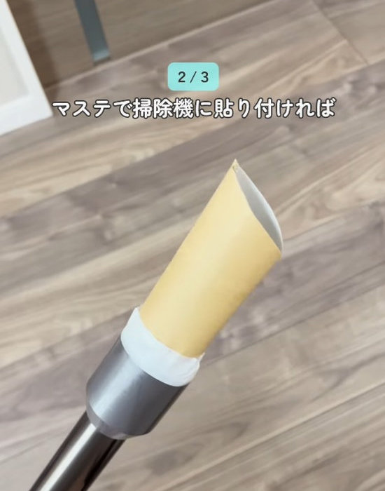 掃除機の先端にトイレットペーパーの芯を取り付ける様子
