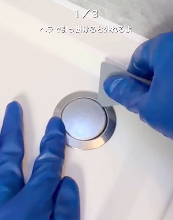 排水栓ボタンにヘラを引っかける様子