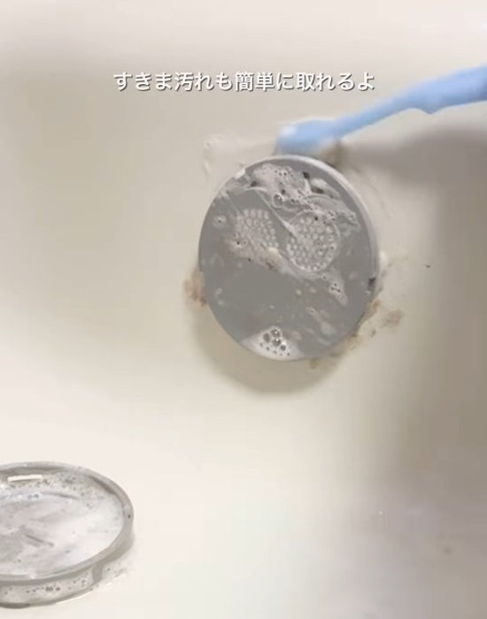 吸水口の中にお風呂用洗剤をかけ歯ブラシでこする様子
