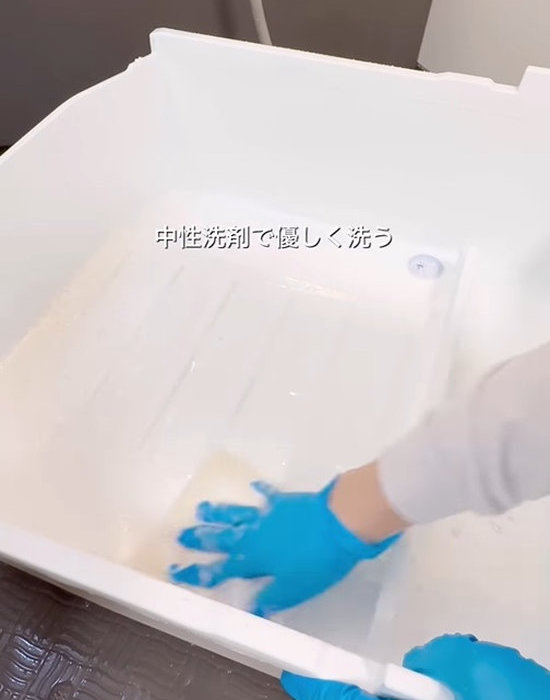 お風呂場で野菜室の引き出しを洗う様子