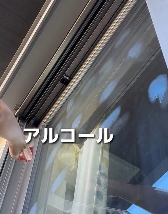 窓ガラスにアルコールスプレーをかけている様子