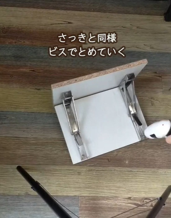 棚板に棚受け金具を取り付けている様子