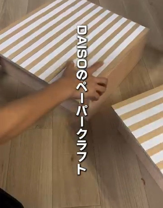 木板にクラフトペーパーを貼り付ける様子