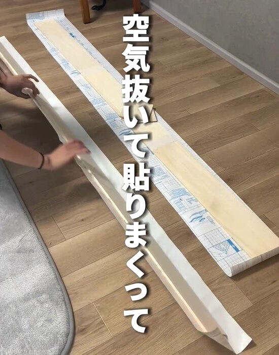 板材にリメイクシートを貼る様子