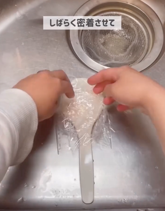 ラップでしゃもじを包む様子