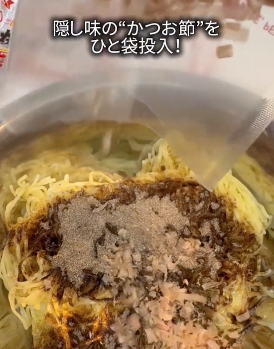 ボウルに焼きそばと粉末ソースとカツオ節を入れる様子