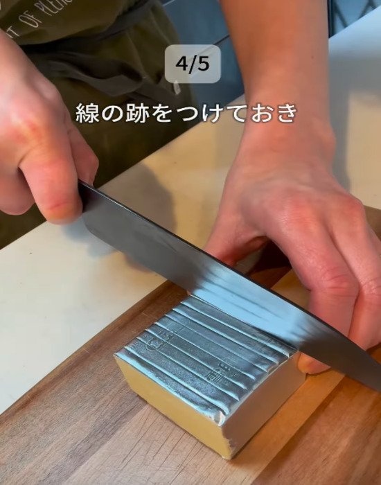バターのアルミホイルの上から包丁で目印を付ける様子