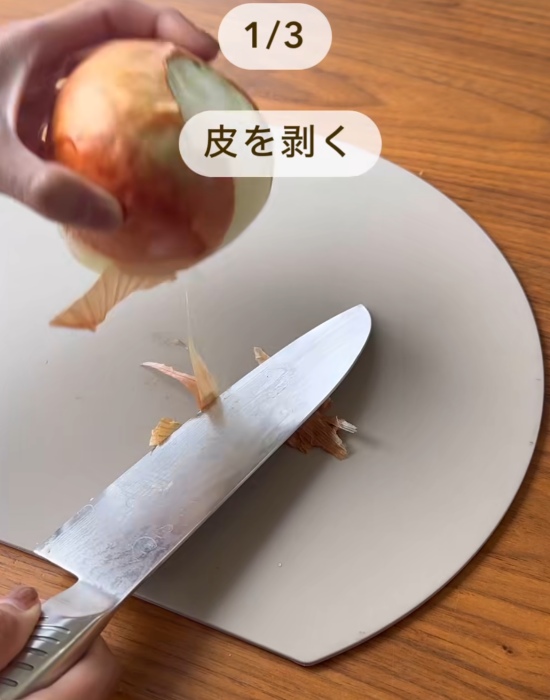 タマネギの皮を包丁でむいている様子