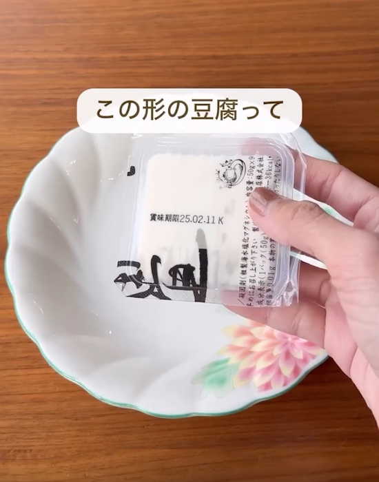 お皿の上で小さな豆腐を手にしている様子