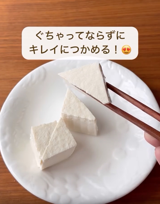 三角に切った豆腐を箸でつまむ様子