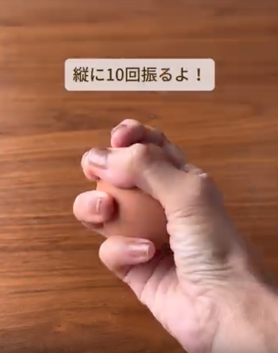 握った温泉卵を振る様子