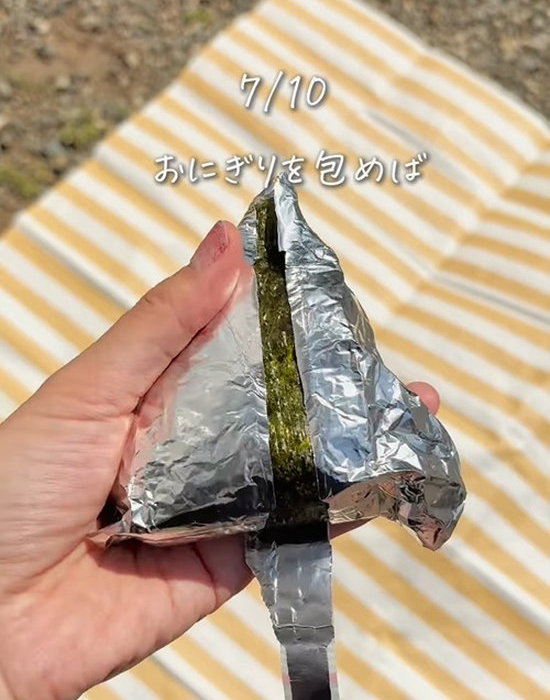 おにぎりのアルミホイルを貼ったテープを剥がしている様子