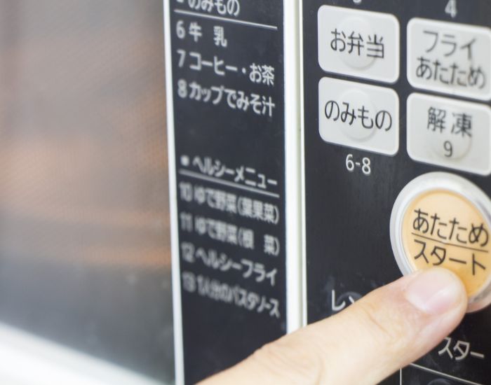 電子レンジの「あたためボタン」を押す様子
