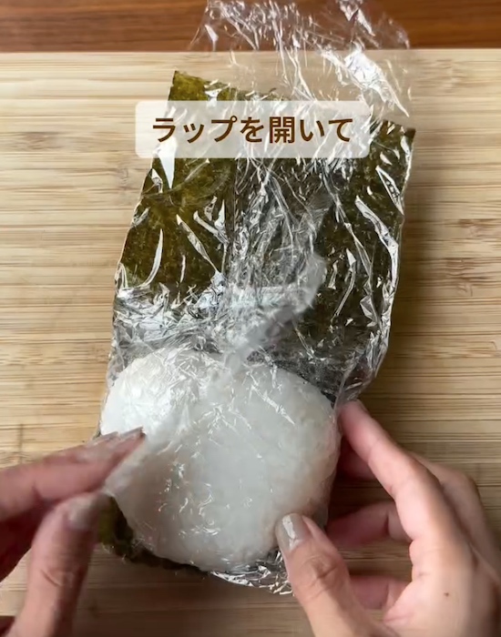 おにぎりを包んだラップを開く様子