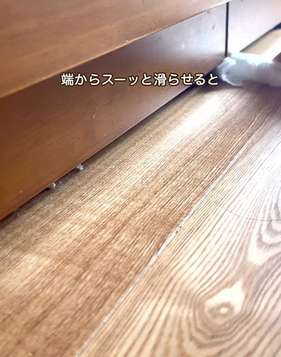 ドライシートを巻いた割り箸でキッチン下を掃除する様子