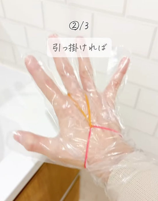 ビニール手袋と輪ゴムを装着した手