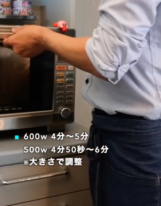 電子レンジの取っ手を持っている状態の男性
