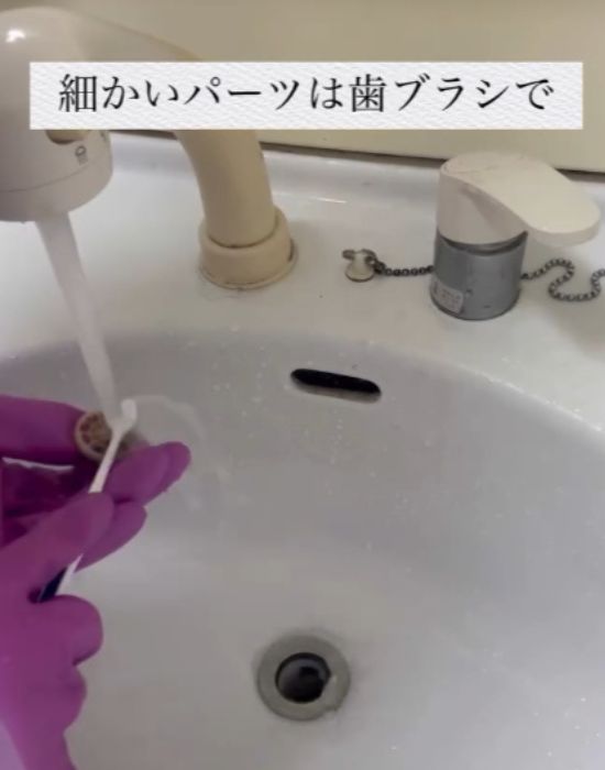排水口の細かいパーツを歯ブラシで磨く様子