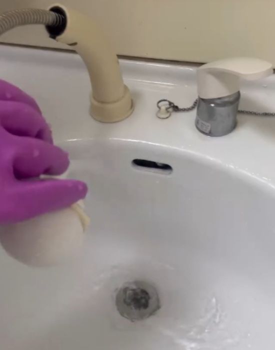 洗面ボウルに水をかけて洗い流す様子