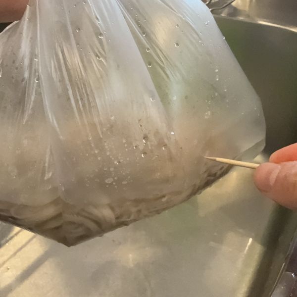 お湯を入れた『アイラップ』の外側につまようじで穴を開ける様子