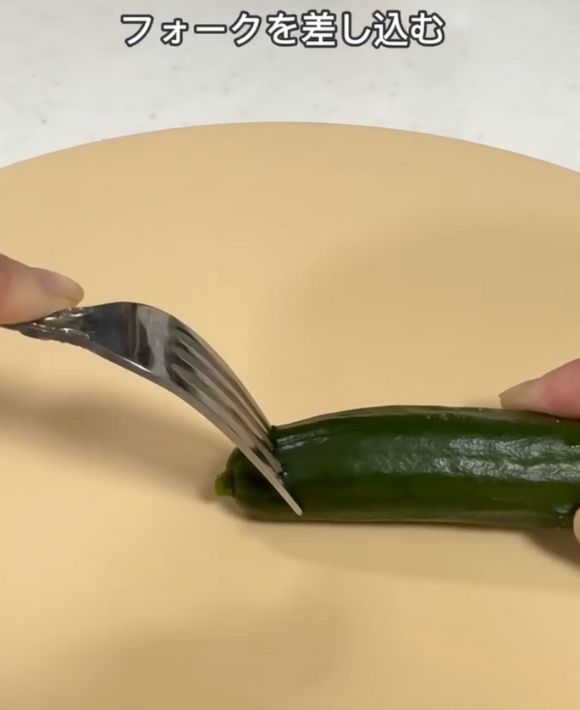 キュウリのへたの部分にフォークを刺す様子