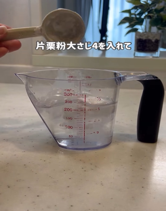 カップに水と片栗粉を入れる様子