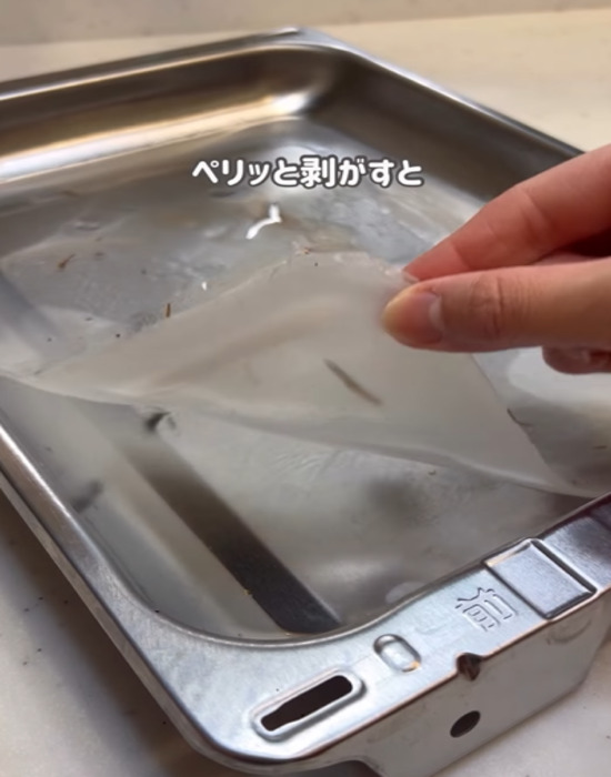 魚焼きグリルの中で固まった片栗粉を剥がす様子