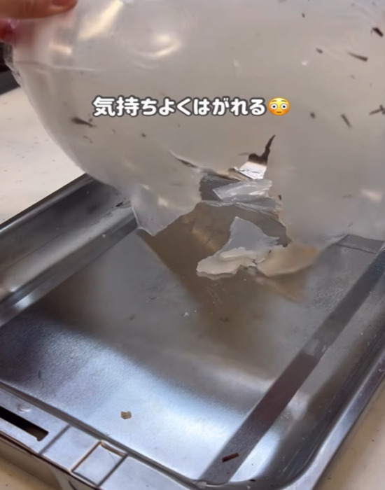 魚焼きグリルの中で固まった片栗粉を剥がす様子