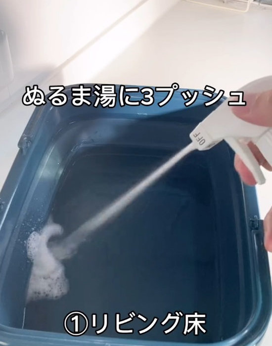 ウタマロクリーナーをバケツに入ったぬるま湯にスプレーしている様子