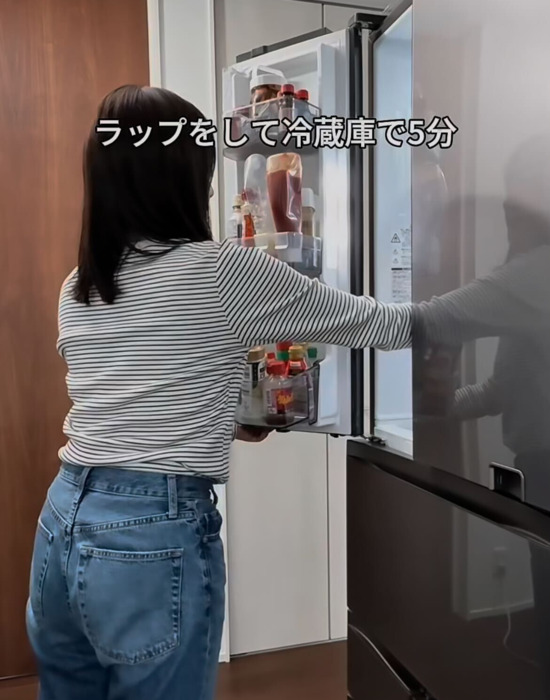 冷蔵庫にボウルを入れる女性