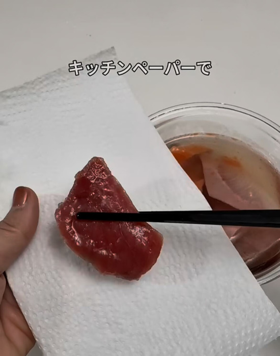 キッチンペーパーで刺身の水気を取る様子