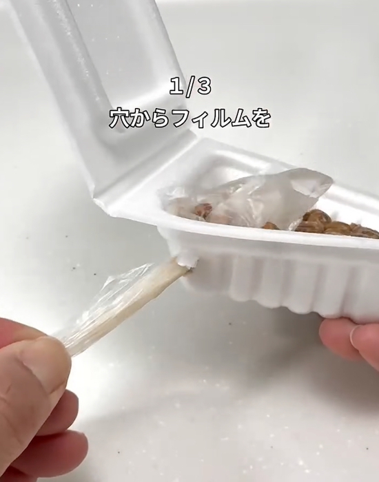 納豆のパックの穴から出ている箸とフィルム