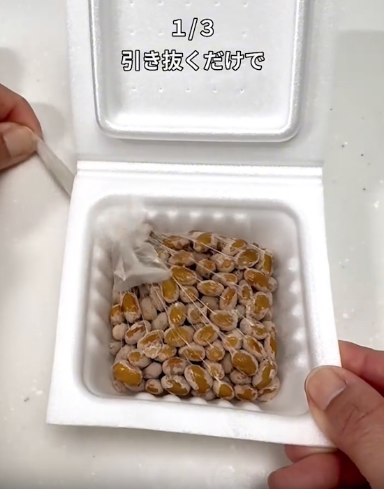 パックの穴から納豆のフィルムを引き出す様子