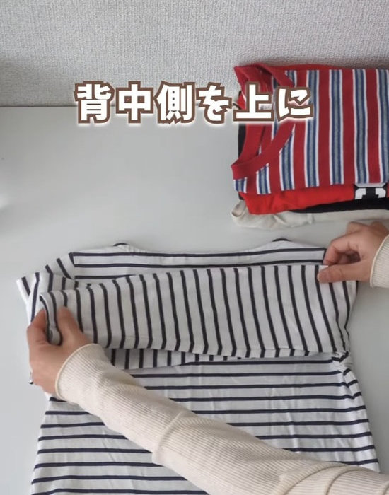長袖Tシャツの袖を折っている様子