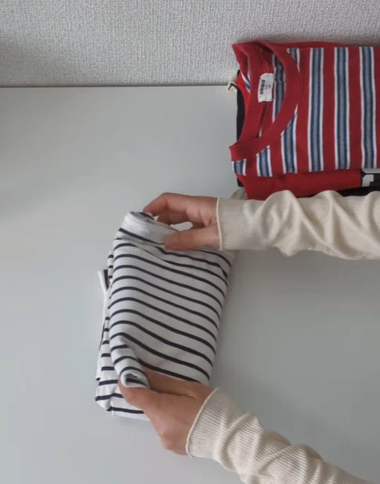 左右の袖を中央に向かって折りたたんでいる様子