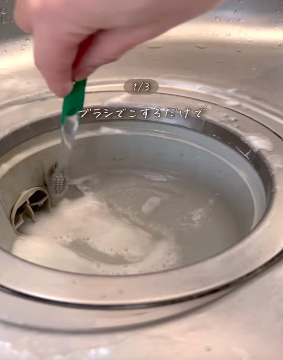 排水口の側面を歯ブラシでこする様子