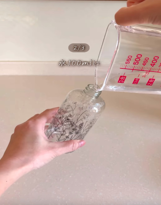 スプレーボトルに水を入れる様子