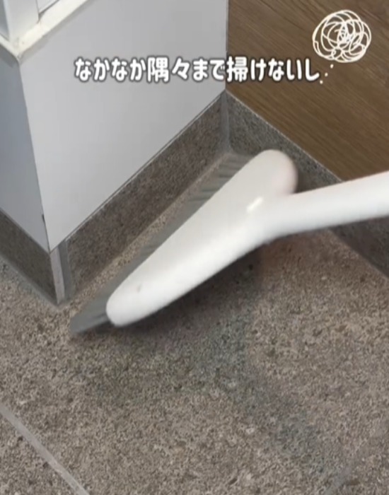 ほうきで玄関を掃除する様子