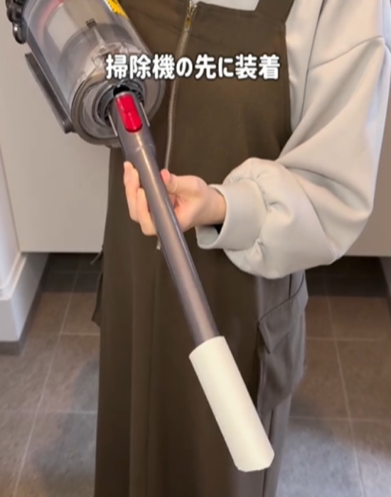 カットしたトイレットペーパーの芯を掃除機の先端に付ける様子