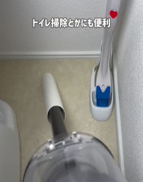 キッチンペーパーの芯を取り付けた掃除機でトイレを掃除する様子