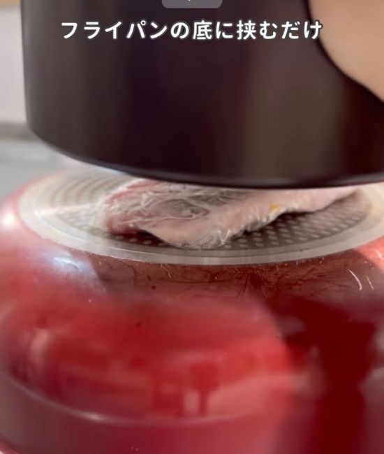 フライパンでお肉を挟む様子