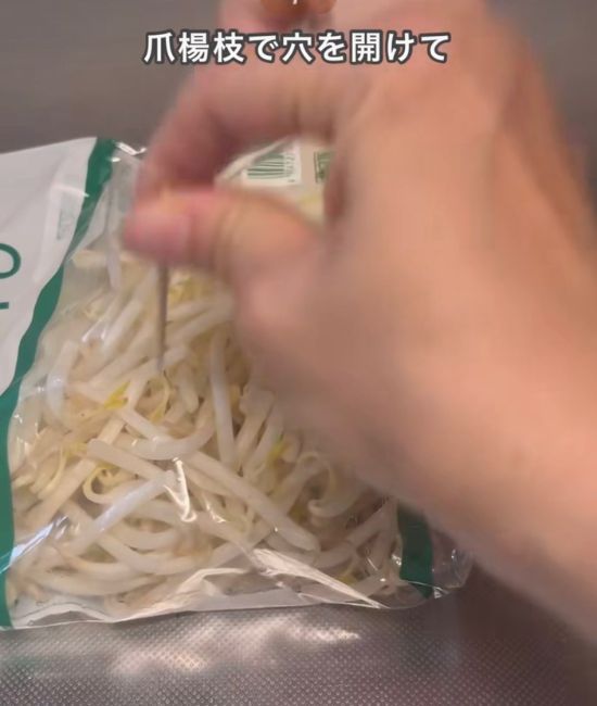 モヤシの袋に穴を開ける様子