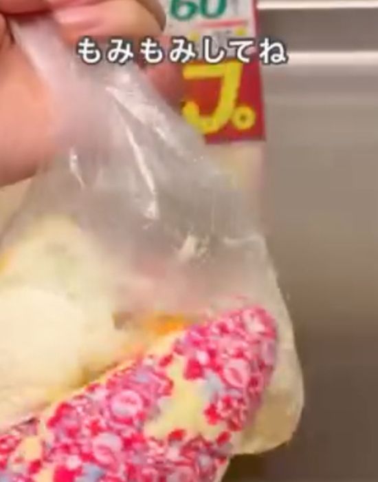 マヨネーズと卵を入れた『アイラップ』をミトンを着けた手でもむ様子