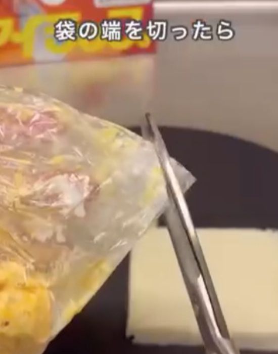 『アイラップ』の袋の端をはさみで切る様子