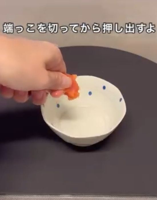 ラップの上からタラコを押して中身を皿に出す様子