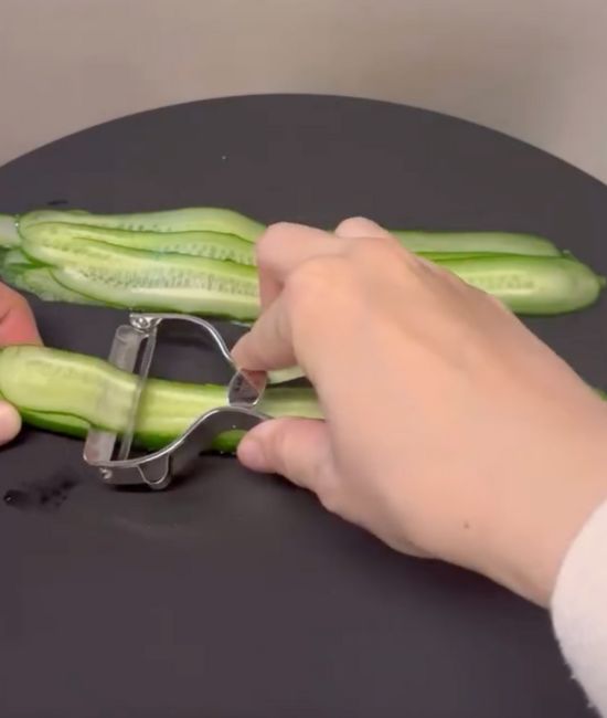 ピーラーでキュウリを細長くスライスする様子