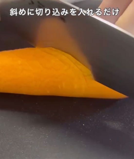 皮をむいたニンジンに包丁で細く斜めに切り込みを入れる様子